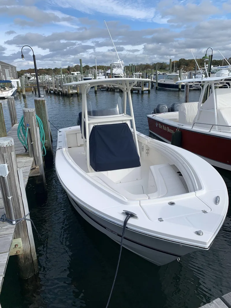 Slide: The Image of 2017 Regulator 23 Forward Seating boat docked in a marina. - 19