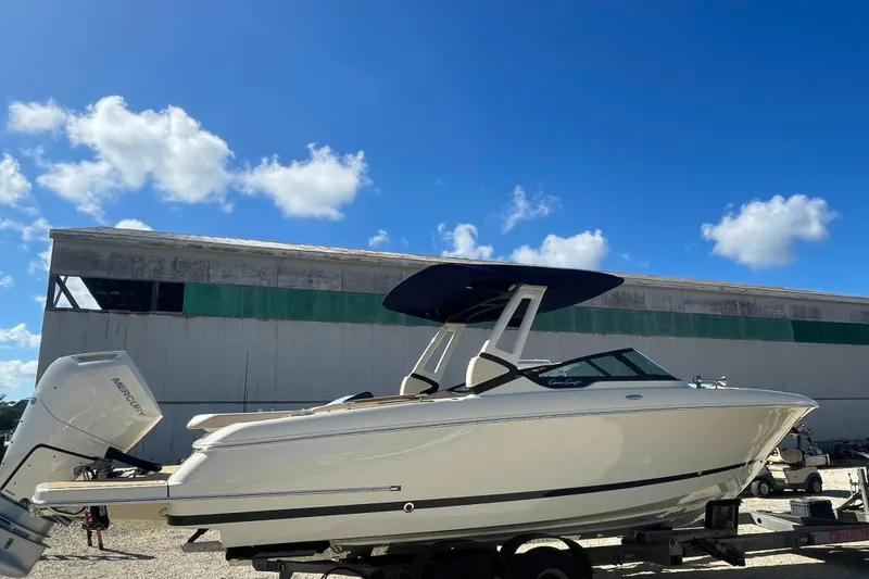 The Image of 2026 Chris-Craft Sportster 28 boat in showroom, featuring sleek design and modern canopy. - 0