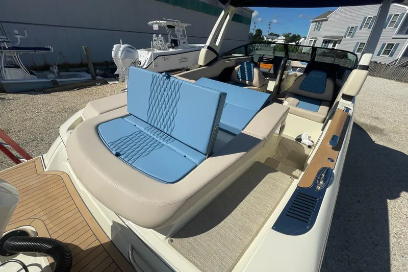 Slide: The Image of 2026 Chris-Craft Sportster 28 boat with sunpad, docked in a marina under clear skies. - 14