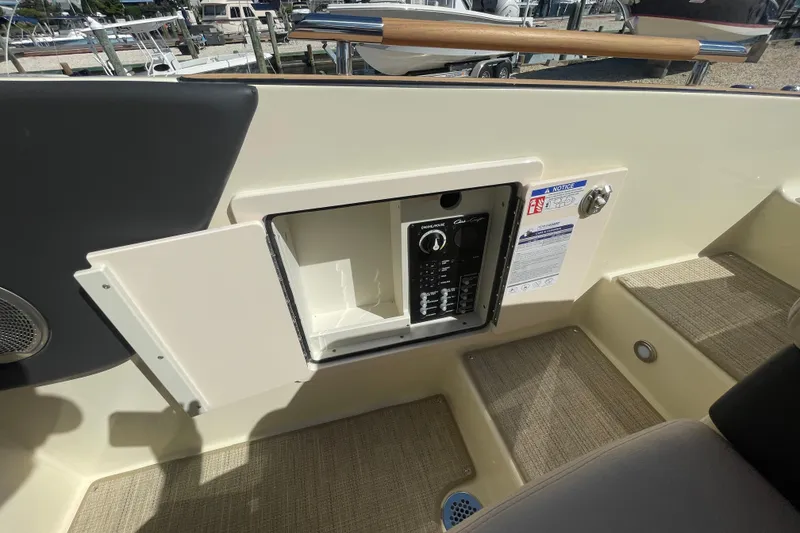 Slide: The Image of 2026 Chris-Craft Sportster 28 boat interior with blue and beige seating and storage compartment. - 16