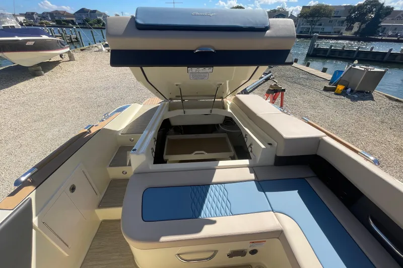 Slide: The Image of 2026 Chris-Craft Sportster 28 boat with luxurious blue and beige seating, docked outdoors. - 18