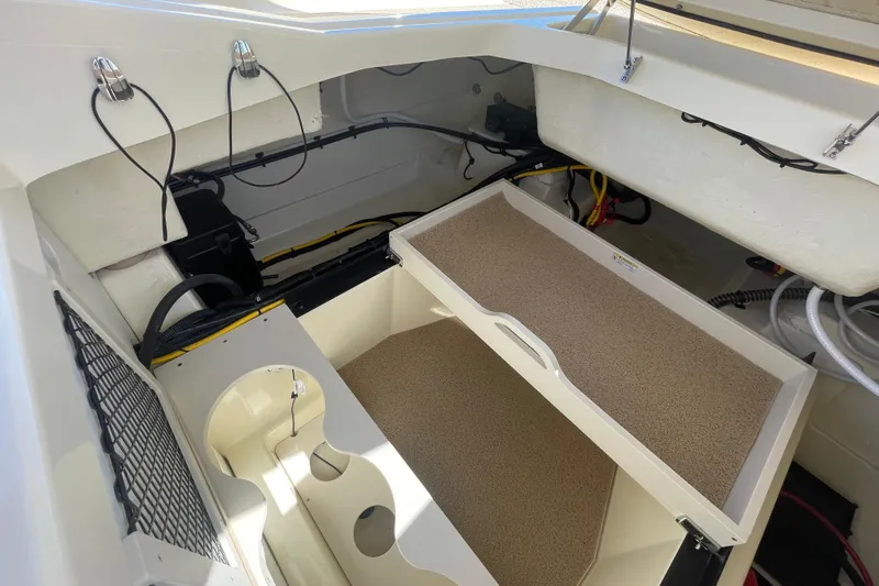 Slide: The Image of 2026 Chris-Craft Sportster 28 boat interior with blue and beige seating, dockside view. - 21