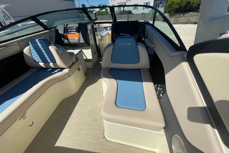 Slide: The Image of 2026 Chris-Craft Sportster 28 boat interior with blue and beige seating, dockside view. - 26