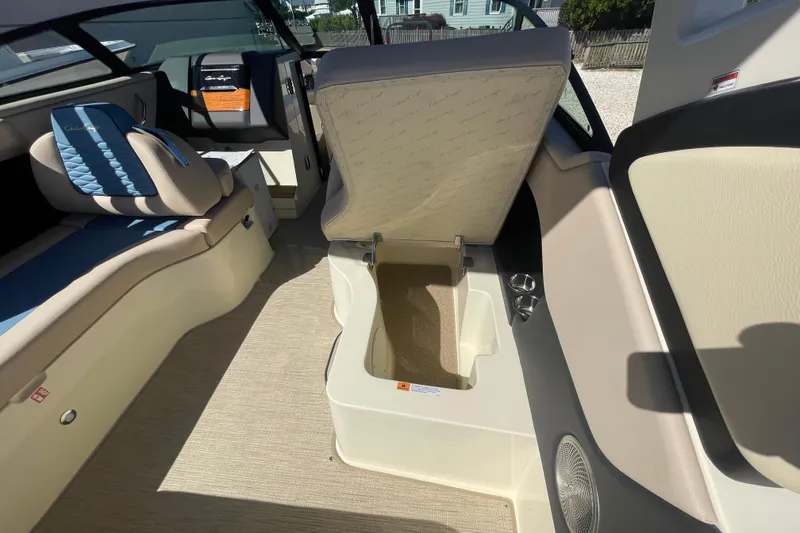 Slide: The Image of 2026 Chris-Craft Sportster 28 interior with blue and beige seating, docked near water. - 27