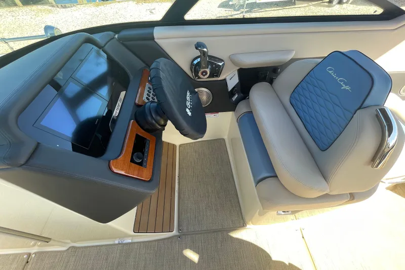 Slide: The Image of 2026 Chris-Craft Sportster 28 interior with blue and beige seating, open storage compartment. - 28