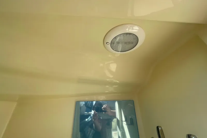 Slide: The Image of 2026 Chris-Craft Sportster 28 interior with blue and beige seating, dockside view. - 45