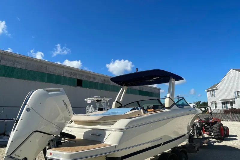 Slide: The Image of 2026 Chris-Craft Sportster 28 boat on trailer under clear blue sky. - 5