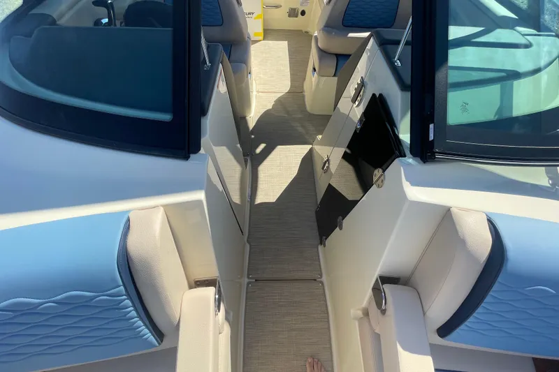Slide: The Image of 2026 Chris-Craft Sportster 28 boat interior with blue and beige seating, docked near another boat. - 53