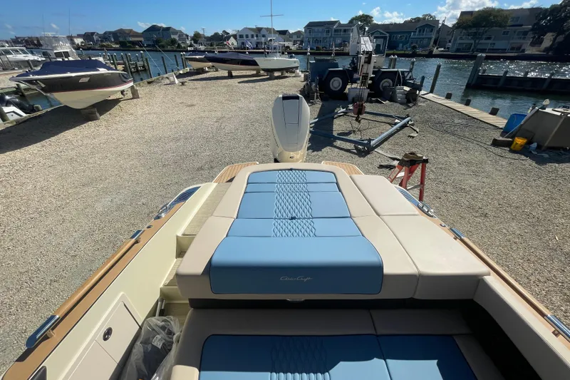 Slide: The Image of 2026 Chris-Craft Sportster 28 interior storage compartment with wood accents and blue seating. - 58