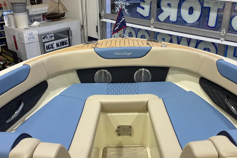 Slide: The Image of 2026 Chris-Craft Sportster 28 boat interior with blue and beige seating, showroom display. - 67