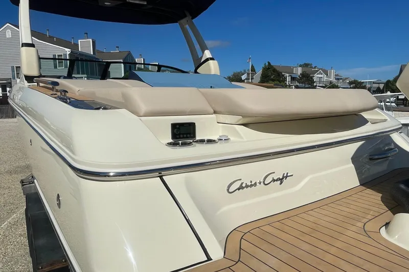 Slide: The Image of 2026 Chris-Craft Sportster 28 boat parked in a residential area under clear blue skies. - 7