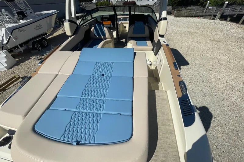 Slide: The Image of 2026 Chris-Craft Sportster 28 boat with Mercury engine, parked outdoors under clear blue sky. - 8