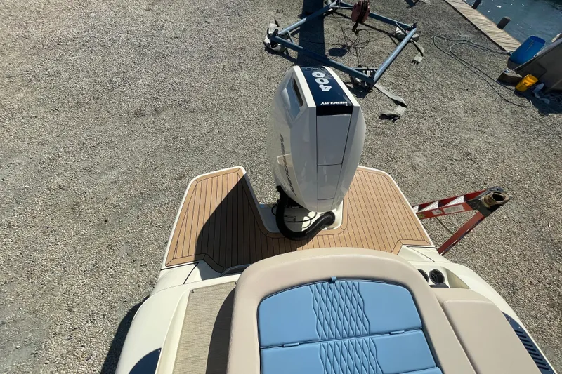 Slide: The Image of 2026 Chris-Craft Sportster 28 boat with Mercury engine, parked outdoors under clear blue sky. - 9