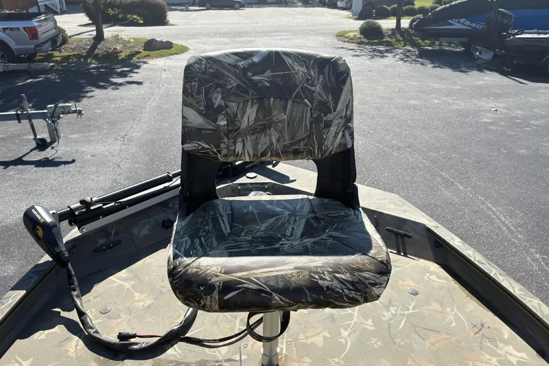 Slide: The Image of 2024 Tracker Grizzly 1754 SC boat seat with camouflage pattern in outdoor setting. - 10