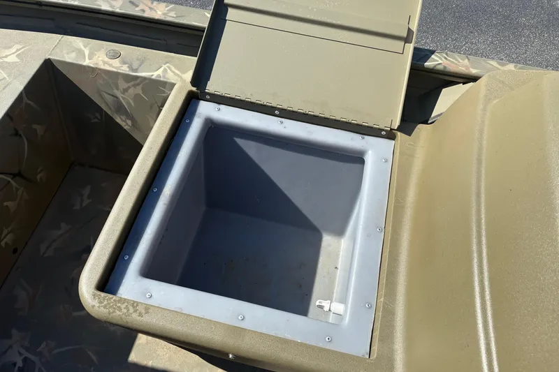 Slide: The Image of 2024 Tracker Grizzly 1754 SC boat storage compartment with open lid, showcasing interior space. - 11