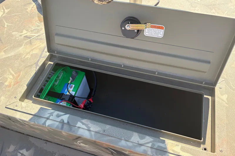 Slide: The Image of Open storage compartment in 2024 Tracker Grizzly 1754 SC boat with battery inside. - 12