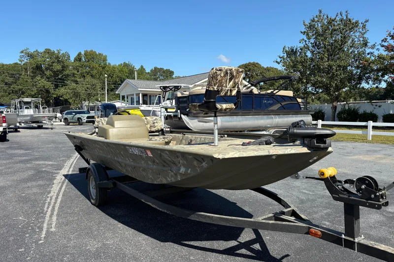 Slide: The Image of 2024 Tracker Grizzly 1754 SC boat on trailer in outdoor setting. - 15