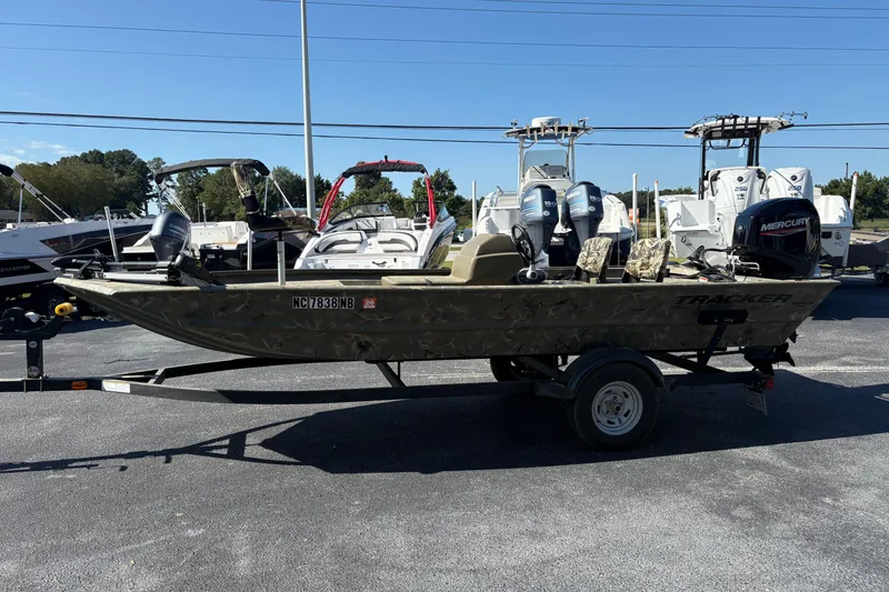 Slide: The Image of 2024 Tracker Grizzly 1754 SC boat on trailer, parked outdoors, with Mercury outboard motor. - 3