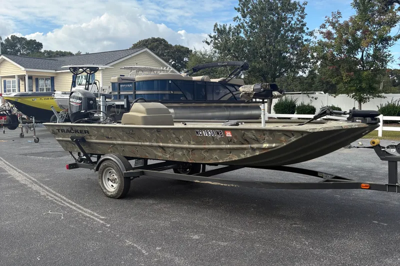 Slide: The Image of 2024 Tracker Grizzly 1754 SC boat on trailer, parked outdoors near residential area. - 5