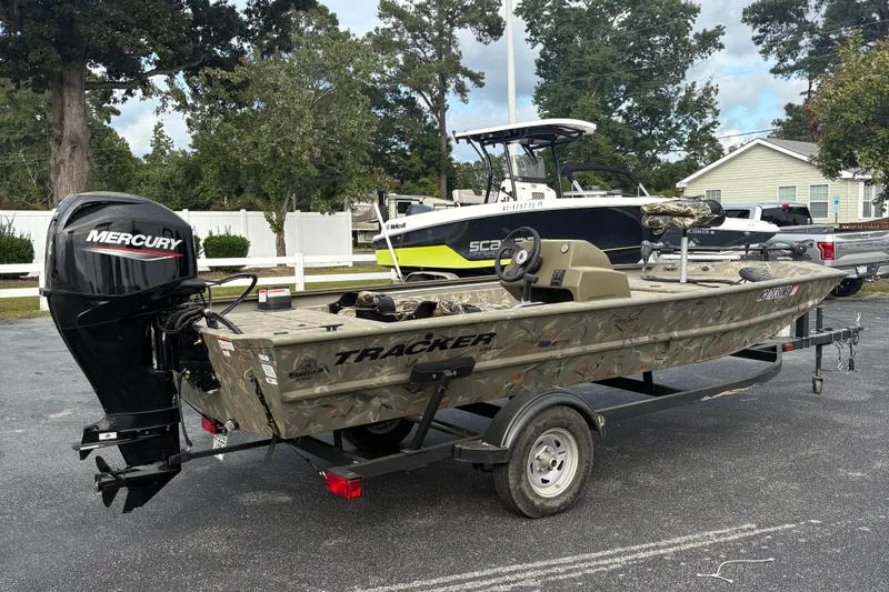 Slide: The Image of 2024 Tracker Grizzly 1754 SC boat with Mercury engine on trailer, parked outdoors. - 6
