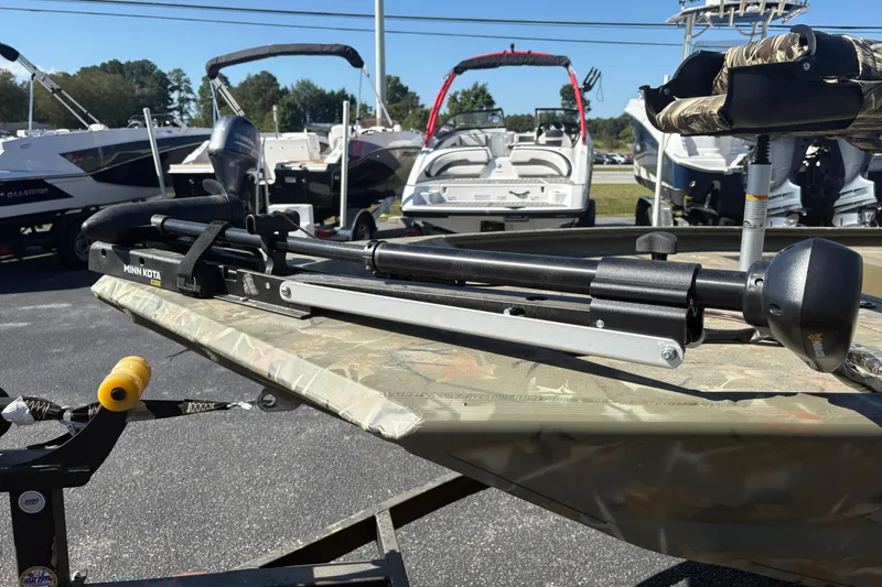Slide: The Image of 2024 Tracker Grizzly 1754 SC boat with Minn Kota trolling motor in a dealership lot. - 8