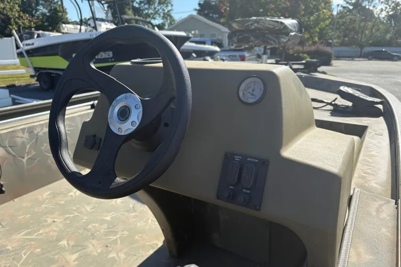 Slide: The Image of 2024 Tracker Grizzly 1754 SC boat console with steering wheel and controls. - 9