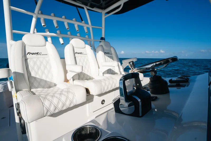 Slide: The Image of 2023 Front Runner 39 Center Console boat interior with white leather seats and steering wheel. - 16
