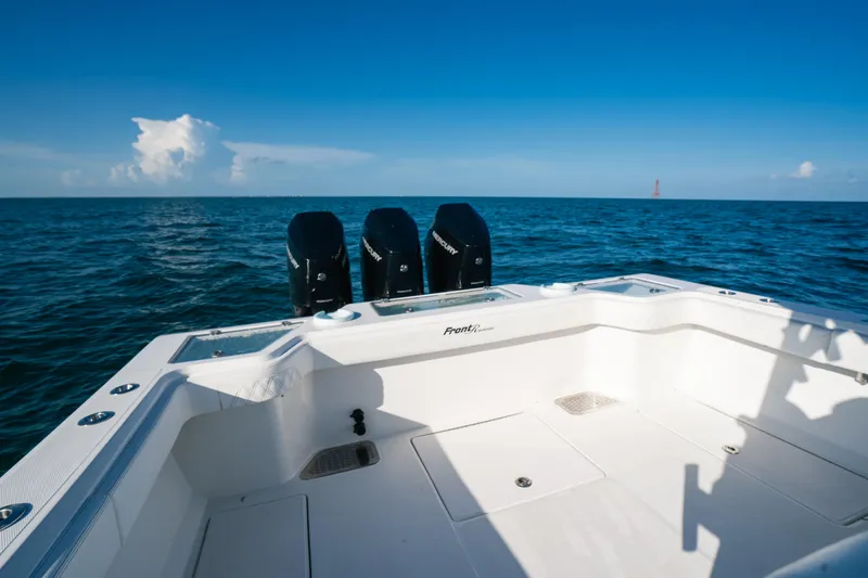 Slide: The Image of 2023 Front Runner 39 Center Console boat on open ocean, featuring triple outboard engines. - 18