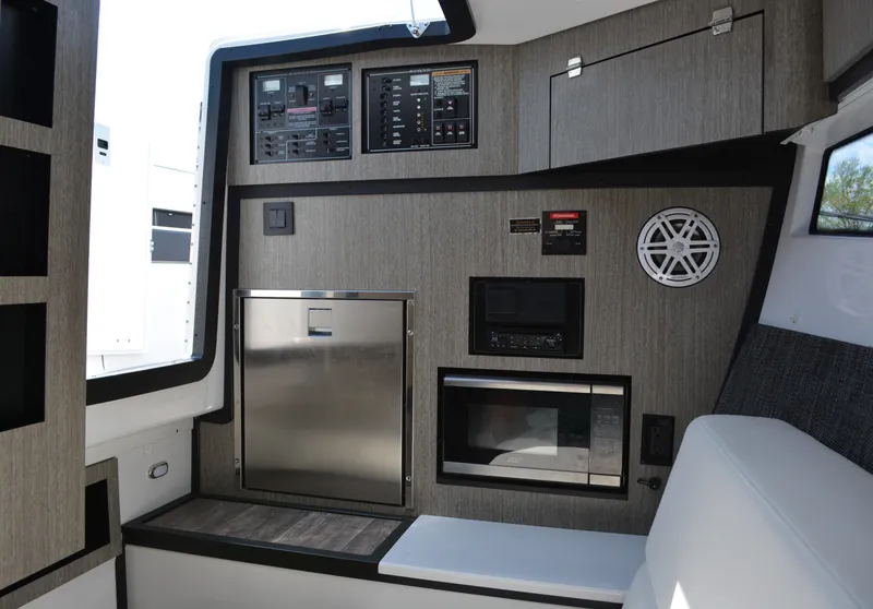 Slide: The Image of 2024 Monterey 378 Super Sport interior with control panels, microwave, and stainless steel fridge. - 19