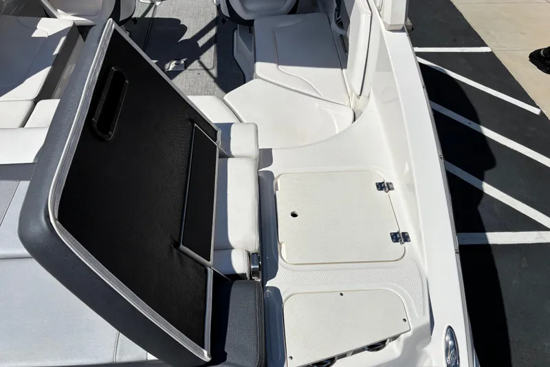 Slide: The Image of 2021 Chaparral 23 Surf boat interior with open storage compartment and seating. - 11
