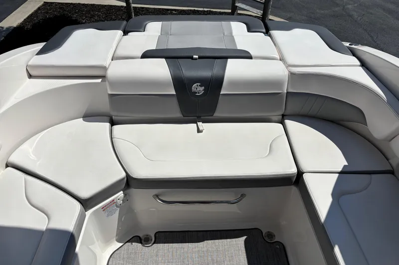 Slide: The Image of 2021 Chaparral 23 Surf boat interior with white cushioned seating. - 13