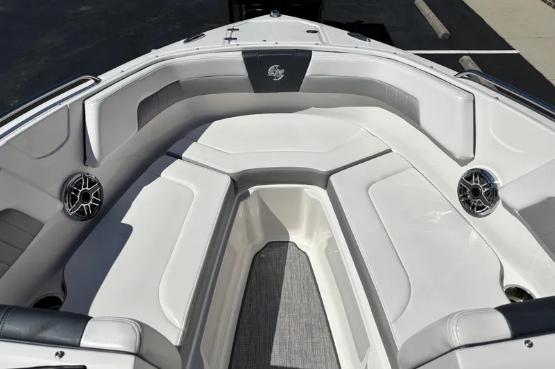 Slide: The Image of 2021 Chaparral 23 Surf boat interior with white seating and speakers. - 14