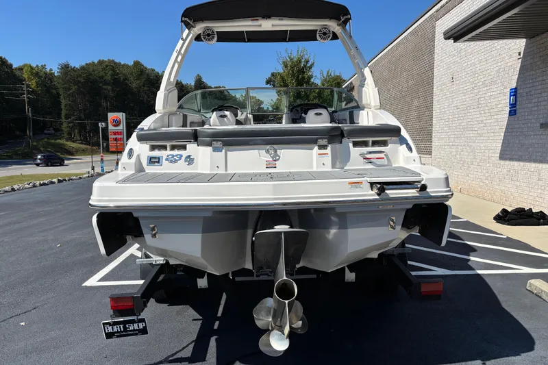 Slide: The Image of 2021 Chaparral 23 Surf boat, rear view, parked in a lot with clear sky. - 3