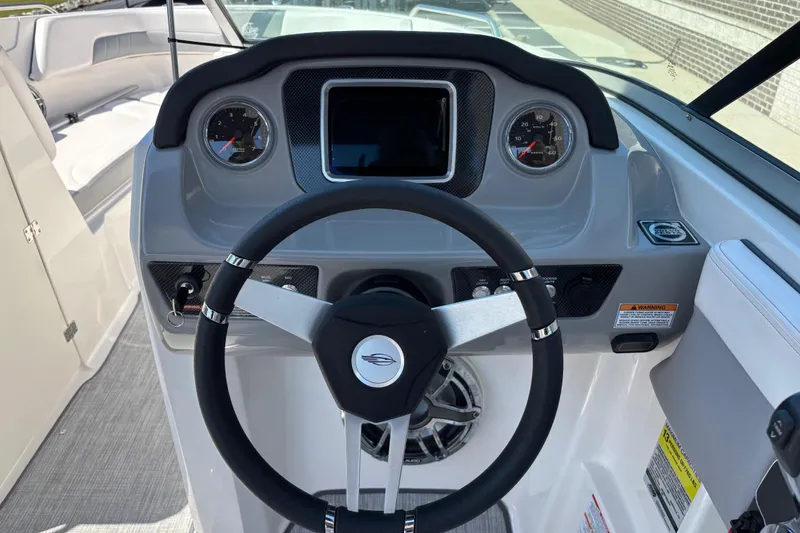 Slide: The Image of 2021 Chaparral 23 Surf boat dashboard with steering wheel and gauges. - 8