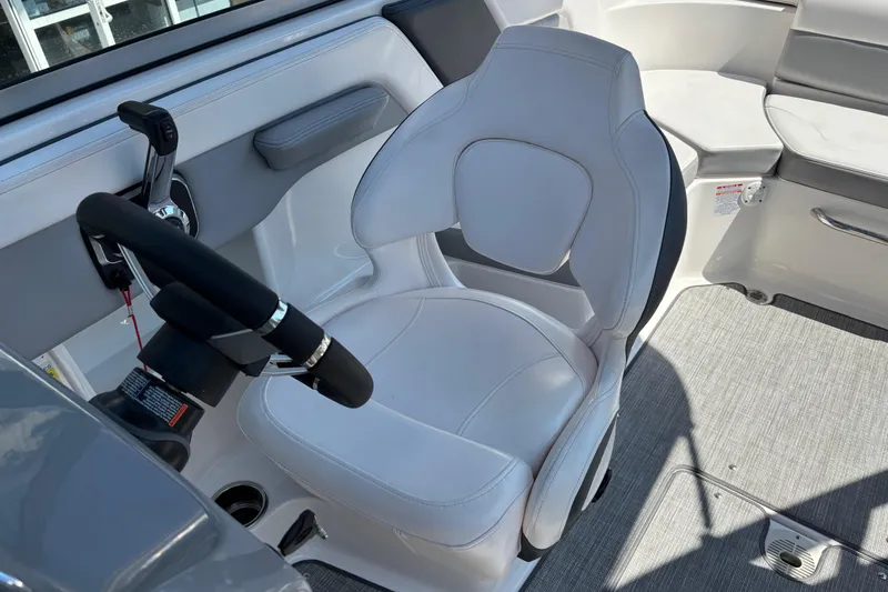 Slide: The Image of 2021 Chaparral 23 Surf boat interior with steering wheel and captain's seat. - 9