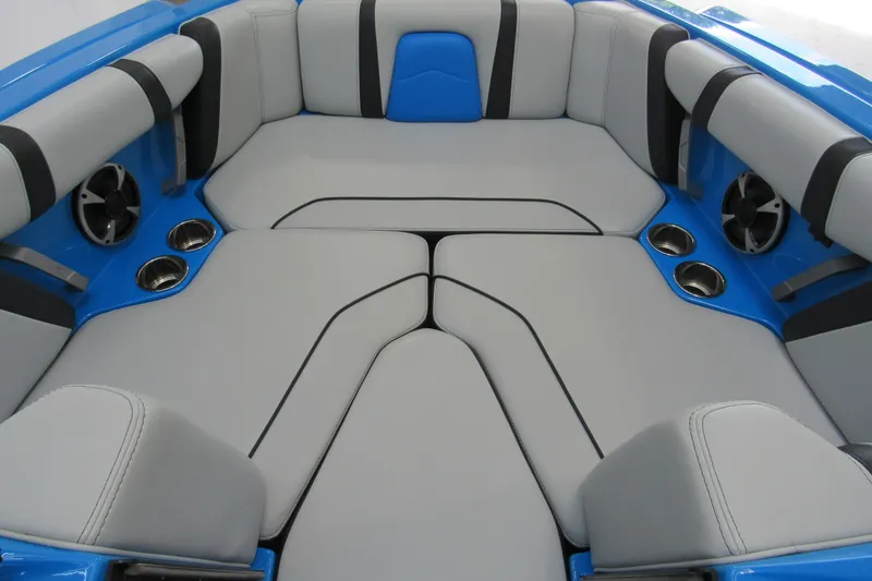 Slide: The Image of 2021 Malibu Wakesetter 21 MLX interior with gray and blue seating, cup holders, and speakers. - 10