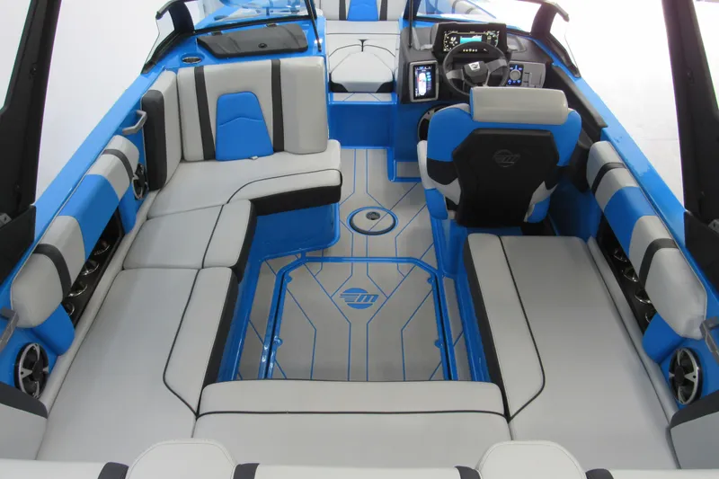 Slide: The Image of 2021 Malibu Wakesetter 21 MLX interior with blue and gray seating, modern dashboard. - 4