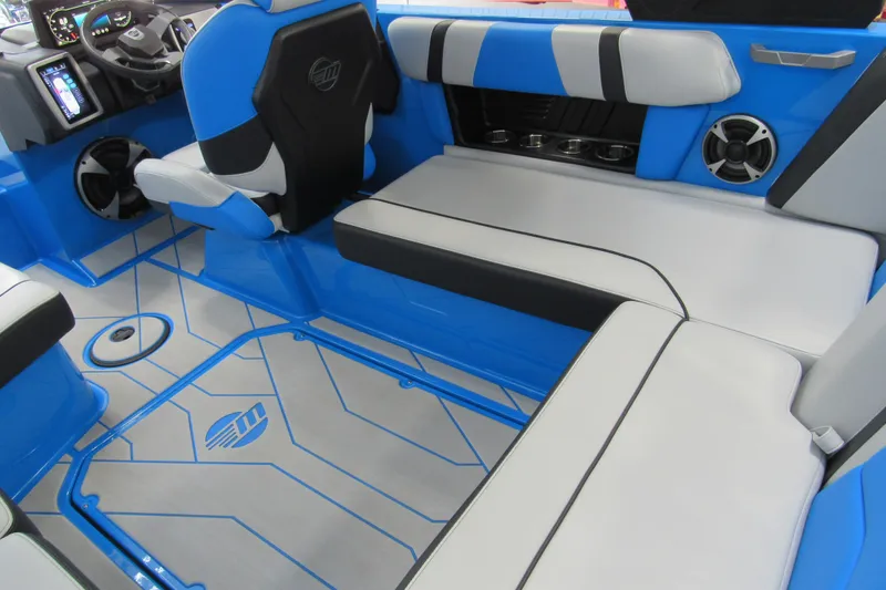 Slide: The Image of 2021 Malibu Wakesetter 21 MLX interior with blue and white seating, modern dashboard, and speakers. - 5