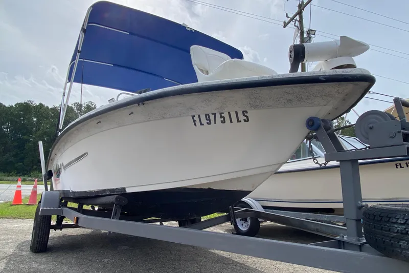 Slide: The Image of 2002 Carolina Skiff 175 boat on trailer with blue canopy, parked outdoors. - 12