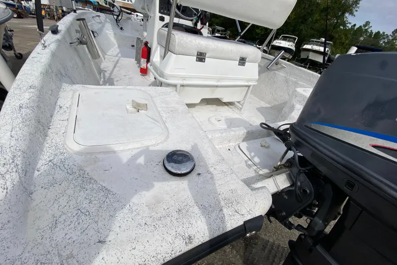Slide: The Image of 2002 Carolina Skiff 175 boat interior with seating and motor, docked outdoors. - 6