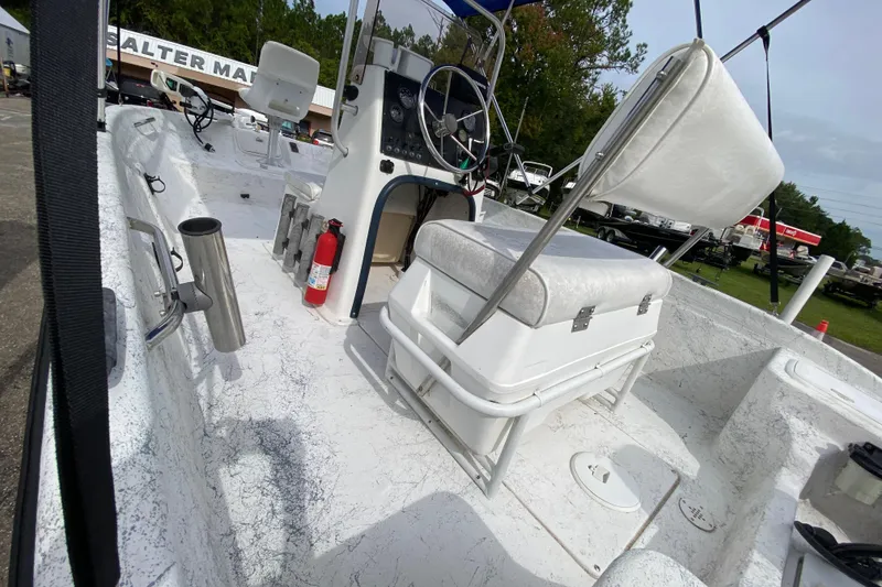 Slide: The Image of 2002 Carolina Skiff 175 boat interior with seating, steering console, and fire extinguisher. - 7