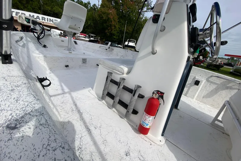 Slide: The Image of 2002 Carolina Skiff 175 boat interior with steering console and fire extinguisher. - 8