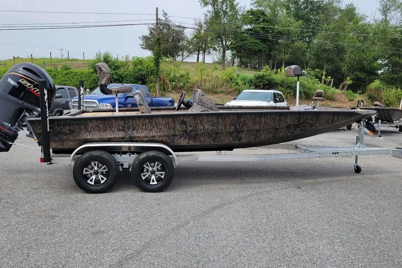 The Image of 2026 Xpress H20 Bass boat on trailer, camo design, parked outdoors. - 1