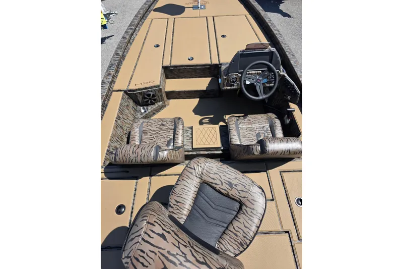 Slide: The Image of 2026 Xpress H20 Bass boat interior with camouflage seats and steering console. - 14