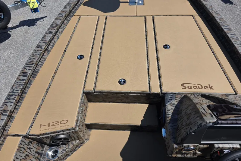 Slide: The Image of 2026 Xpress H20 Bass boat deck with SeaDek flooring, showcasing camo design. - 15