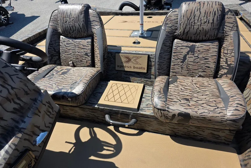 Slide: The Image of 2026 Xpress H20 Bass boat interior with camo-patterned seats and steering wheel. - 19