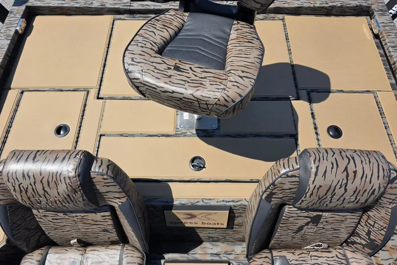 Slide: The Image of 2026 Xpress H20 Bass boat interior with camouflage seating and storage compartments. - 26
