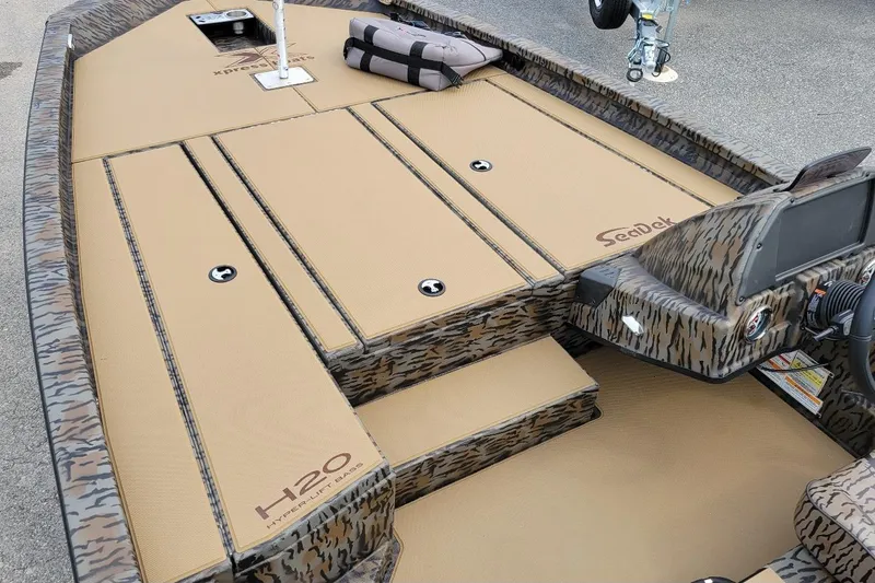 Slide: The Image of 2026 Xpress H20 Bass boat interior with camo design and SeaDek flooring. - 4