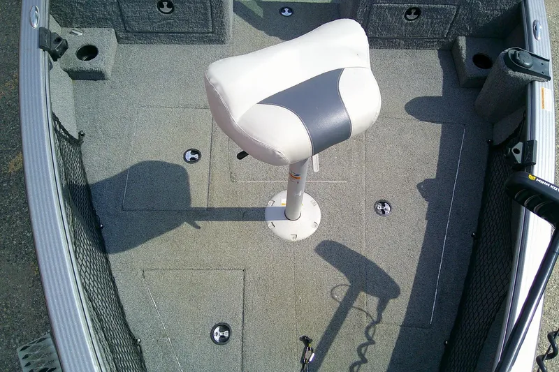Slide: The Image of 2016 Lund 2025 Impact boat interior with a central white seat and gray carpet. - 12