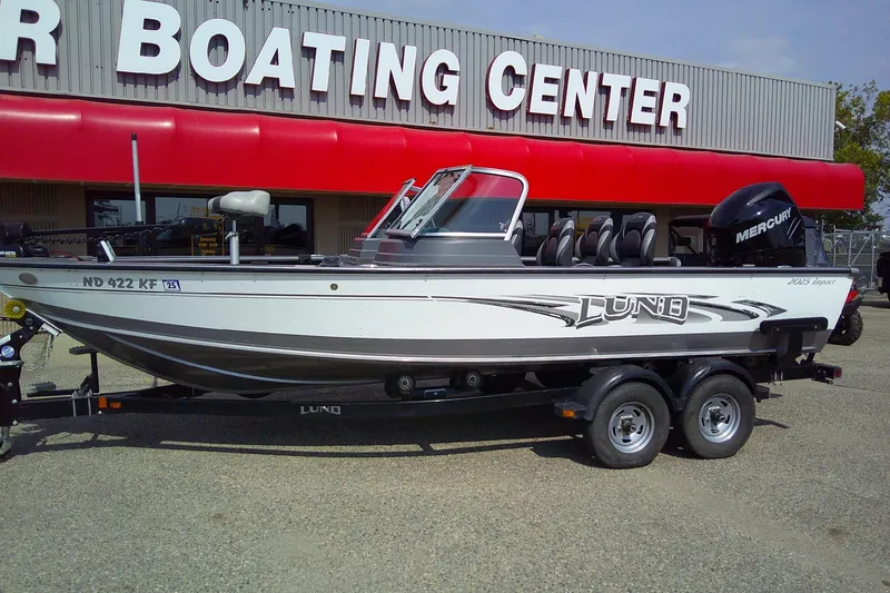 Slide: The Image of 2016 Lund 2025 Impact boat on trailer outside boating center. - 3